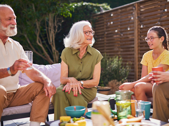 Family dining together around BBQ area.