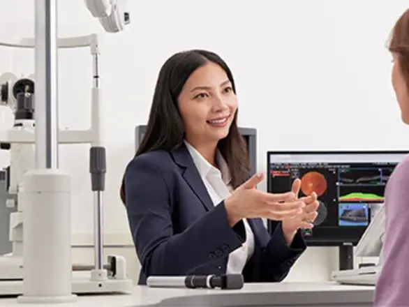 A friendly optometrist giving advice to a patient in the test room.