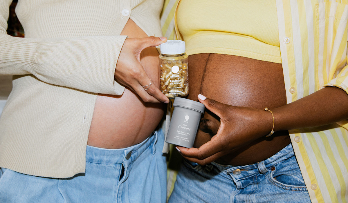 Two pregnant models, one holding a bottle of Essential for Women Prenatal Multivitamin and the other holding a bottle of Natal Choline.