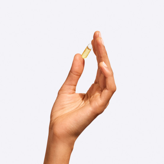 An Omega-3 DHA & EPA capsule in a model's hand.