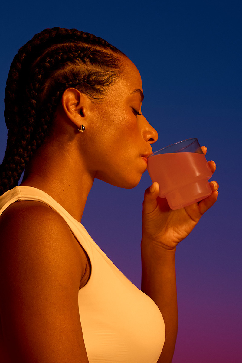 Women drinking Magnesium+ from glass.