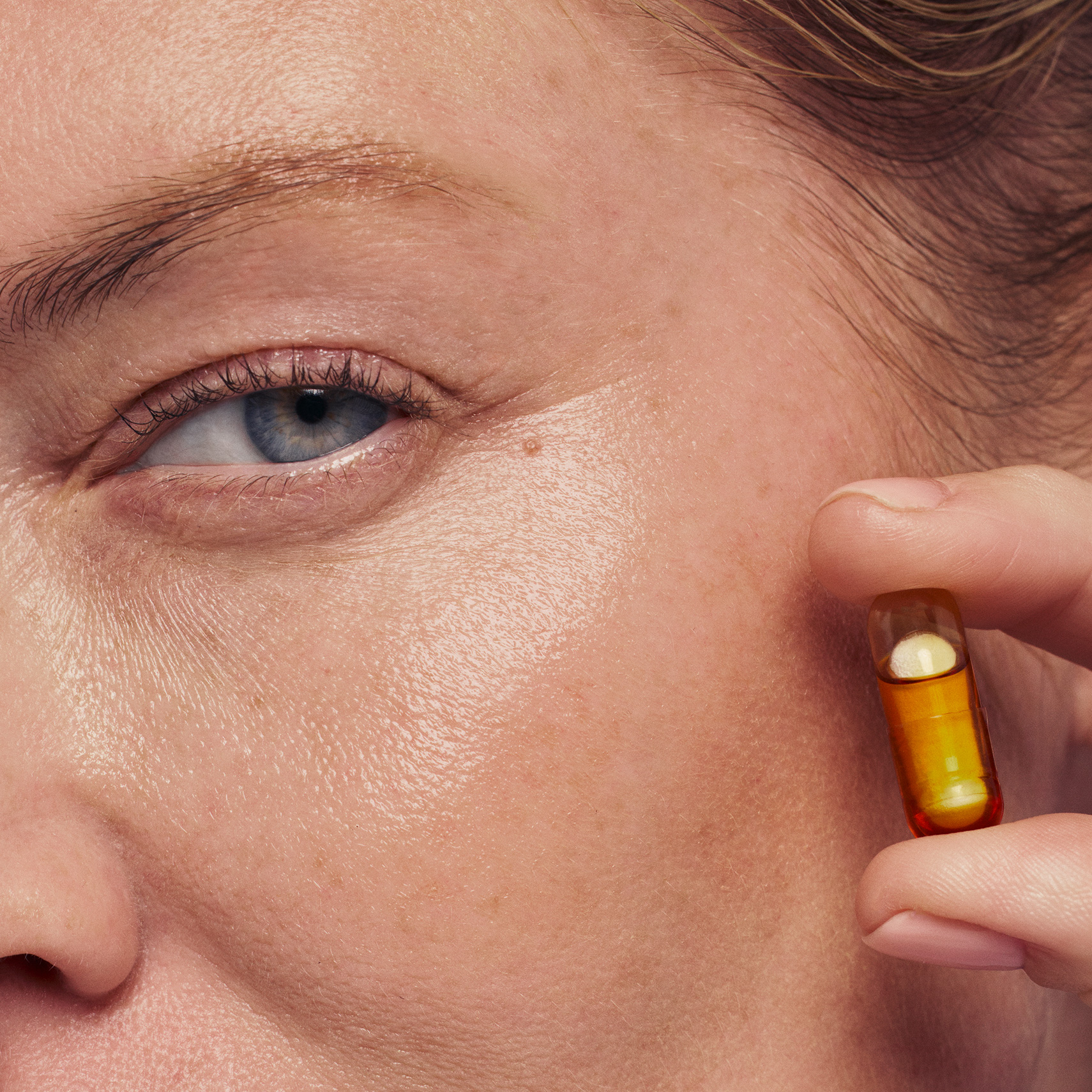 Model holding HyaCera capsule up to face