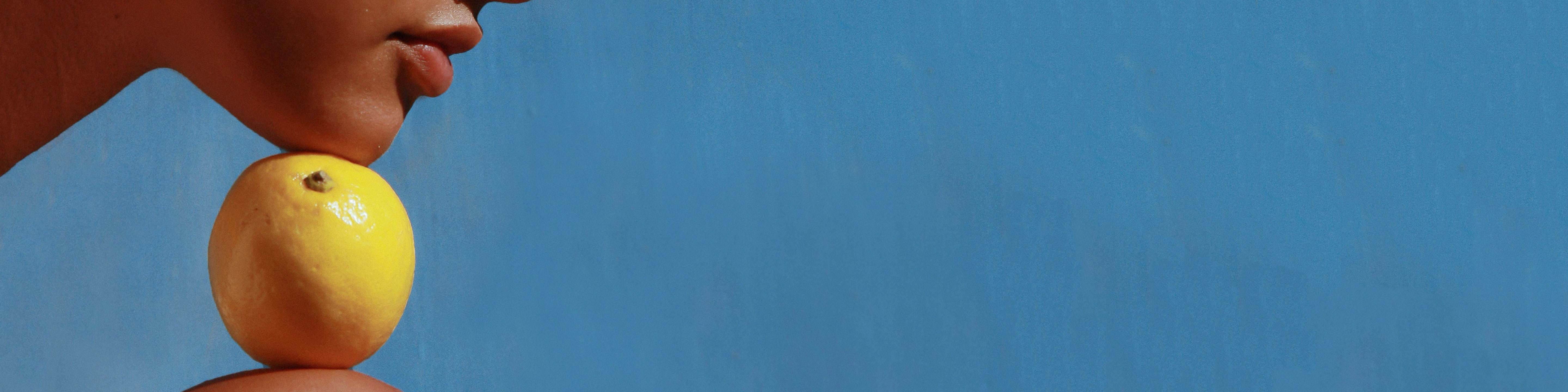 Woman placing her chin on fruit.