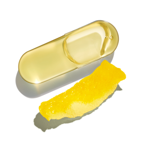 An Omega-3 DHA & EPA capsule next to a lemon rind on a transparent background.
