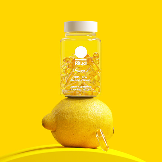 Omega-3 DHA & EPA bottle balances on a lemon with a capsule.