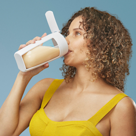 Side profile of a woman drinking a shake made with Ritual protein powder