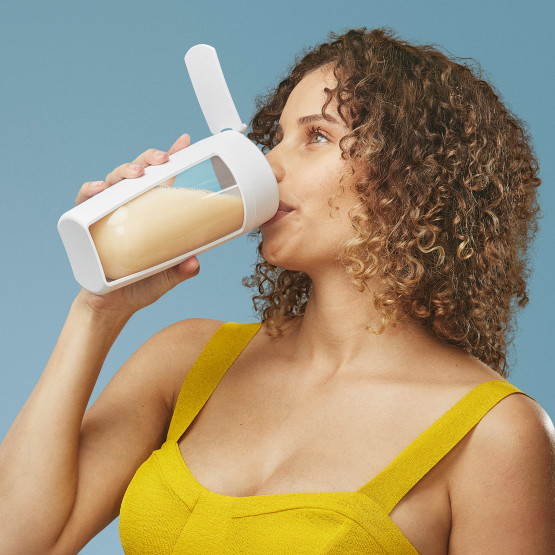 Side profile of a woman drinking a shake made with Ritual protein powder