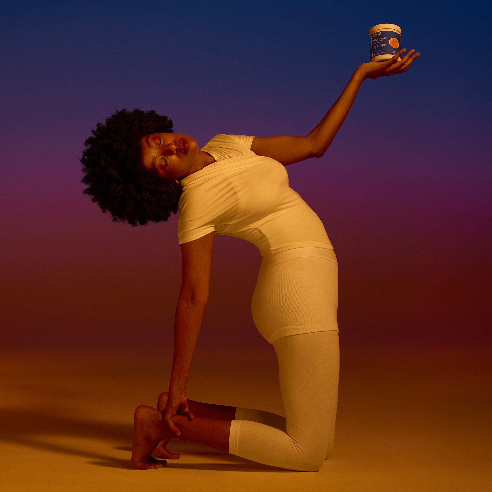 Person in yoga pose holds Ritual Magnesium+.