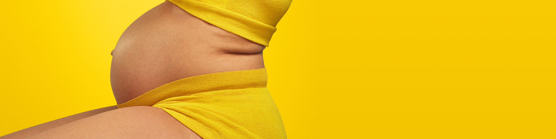 Person with pregnant bump wearing yellow.