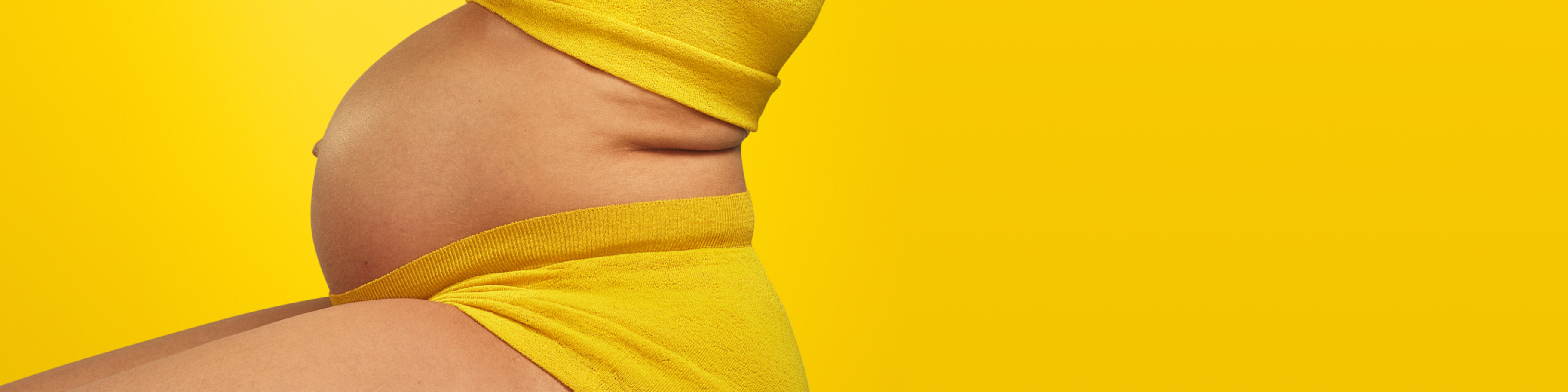 Person with pregnant bump wearing yellow.