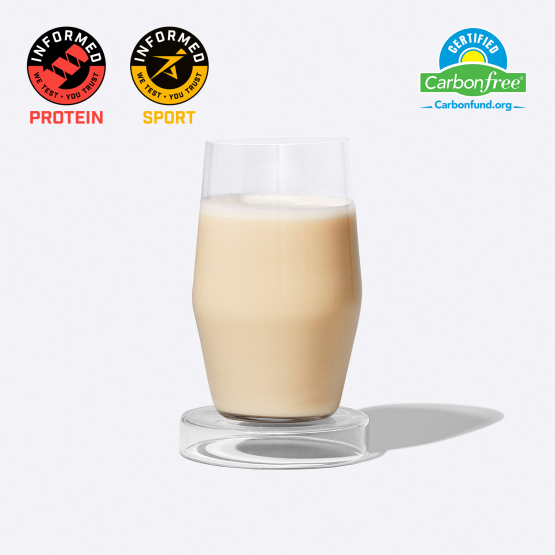 A photo of a glass cup filled with a Ritual protein shake; includes Informed Protein and Informed Sport Certifications