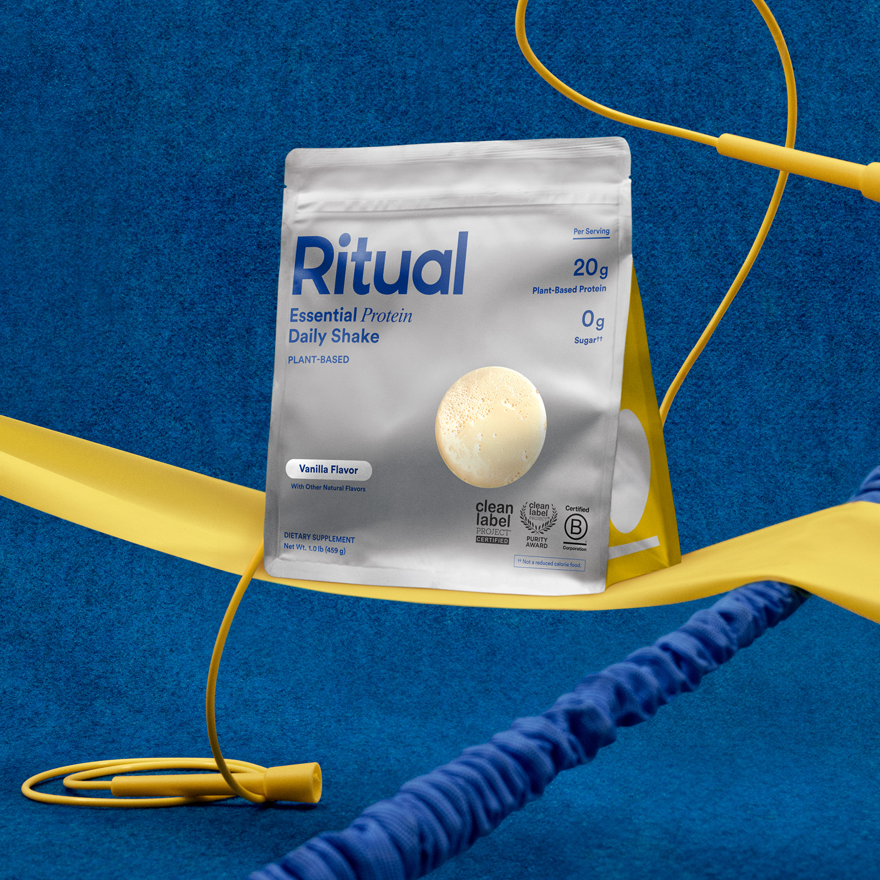 A bag of Essential Protein Daily Shake with blue background and yellow exercise equipment props.