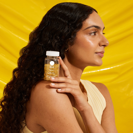 A model with an Omega-3 DHA & EPA bottle rested on their shoulder.