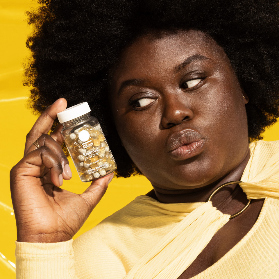 Woman holding Ritual's multivitamin bottle.