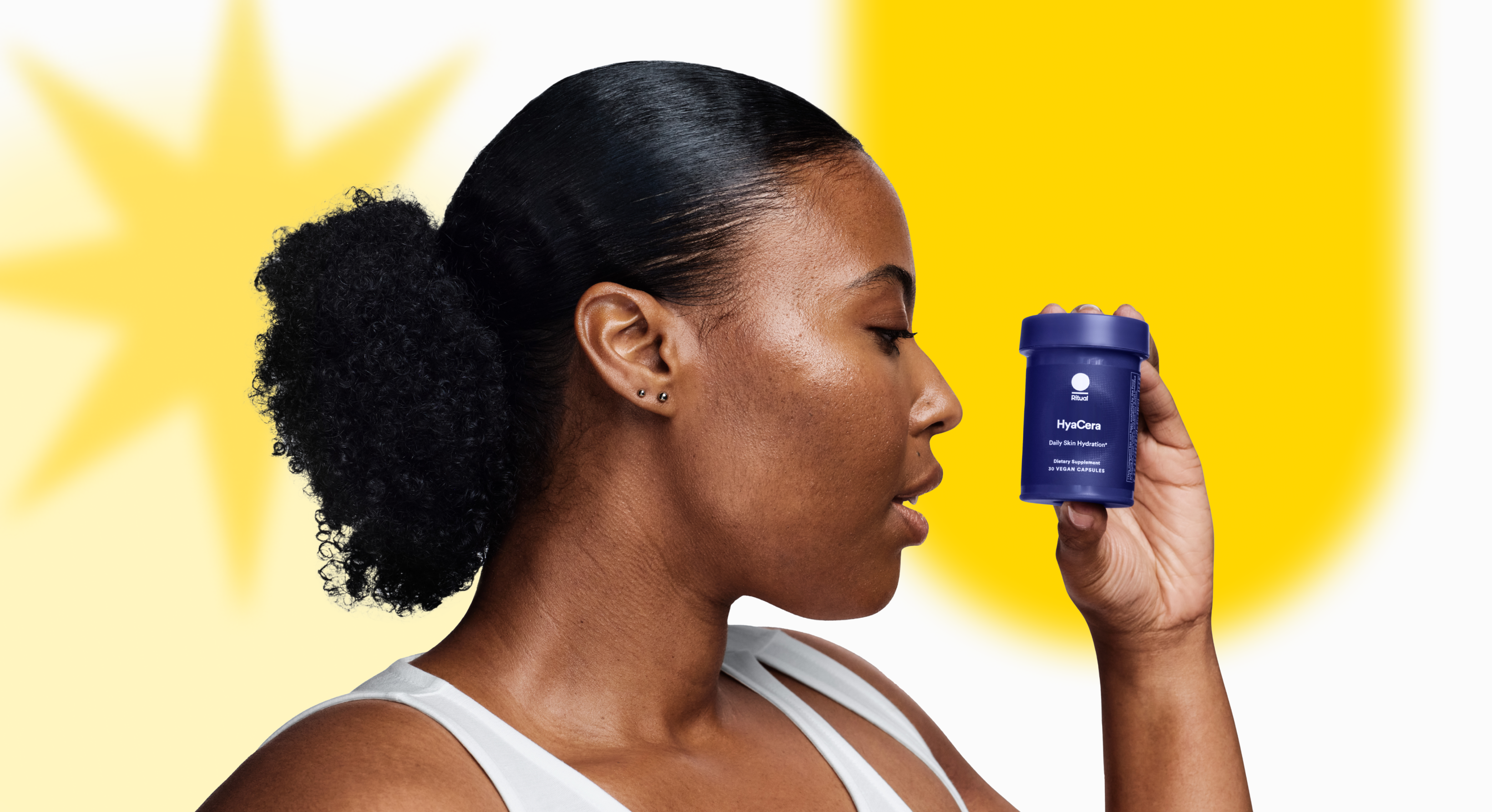 Image of a model holding a bottle of HyaCera™ with decorative yellow graphics in the background