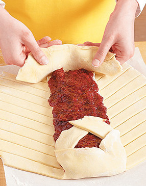 Fold flaps on both ends of the braid up and over the filling. Tuck in the excess dough like bed sheets.