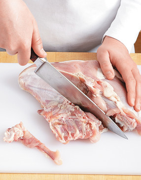 Trim the excess bones and fat from the breasts with a chef's knife and reserve them to make the stock.