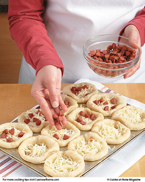 Fill the parbaked dough cups with pizza toppings, then place the cups back in the oven to finish baking.