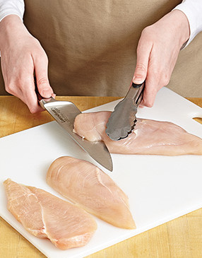 Keep your knife parallel to the cutting board to ensure you halve the chicken breasts evenly.