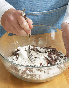 To prevent overworking the dough, cut batter into dry ingredients, stir in chocolate pieces, then add liquids.