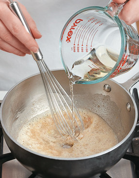 The flour mixture will “seize” when the wine is added, but just continue to whisk while adding the wine.
