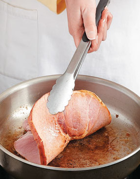 Searing the ham heats up the meat while leaving flavorful bits in the pan with which to make the sauce.
