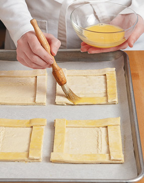 Place strips around edges of pastry squares to form a border. Brush edges and corners with egg wash.