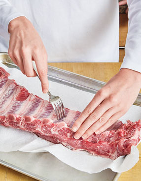To help the rub penetrate into the meat, dock the ribs by inserting a fork between the bones.