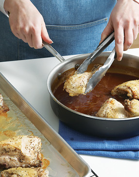 Dip chicken into sauce &mdash; since it's cooked, there's no need to worry about cross contamination.