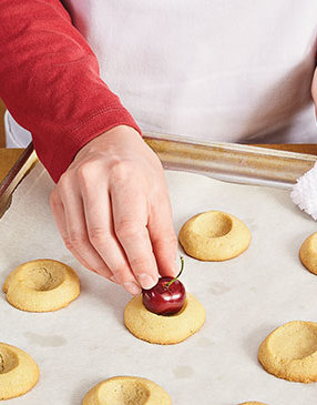 Since they’re on hand, use a fresh cherry to indent the cookies again once they come out of the oven.
