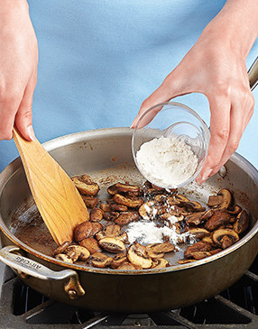 Adding the flour to the mushrooms will coat them and help thicken the gravy once the broth is added.