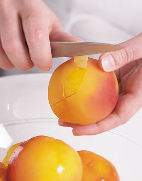 2) Use a paring knife to easily peel away peach skins. Start pulling skin at the end where the X was cut in each peach.