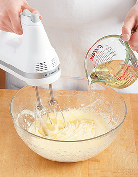 To easily incorporate the oil, drizzle it in with the mixer running. The batter thickens as you add it.