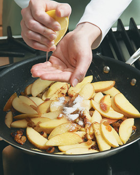 Squeeze lemon over apples &mdash; cup your hand over the pan to keep seeds out of the mixture.