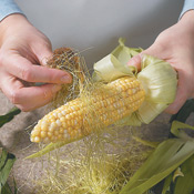 After peeling the husks, remove and discard the corn silk.