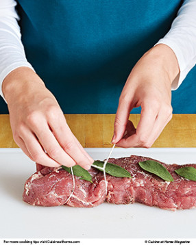 So the tenderloin holds its shape, tie it with kitchen string, and add sage leaves for flavor.