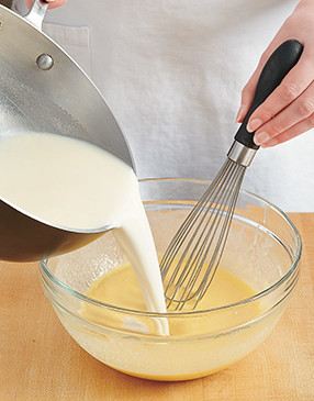 So the cold eggs don’t curdle, whisk the hot milk mixture into the egg mixture to temper them.