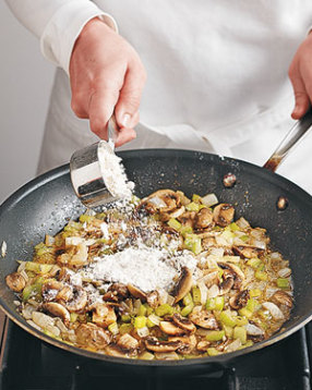 Sprinkle the flour over the mushroom mixture to soak up the butter and to thicken the sauce.