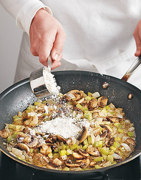 Sprinkle the flour over the mushroom mixture to soak up the butter and to thicken the sauce.