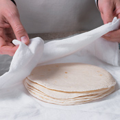 Wrap tortillas loosely in a damp towel; then wrap in foil. Place packet on unlit side of grill. The heat from the other side of the grill will steam the tortillas, making them pliable. 