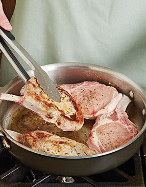 So the chops have color, sear them in a pan first, then add them to the baking sheet to finish cooking.