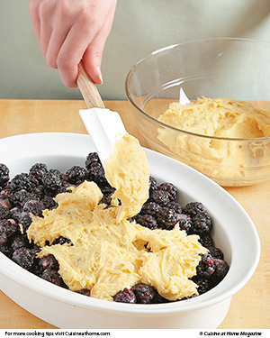Spoon and gently spread the dough over the berries. It will be thin in spots, but it spreads as it bakes.