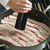 Grind pepper onto the bacon as it starts to cook. This will infuse the strips with flavor.