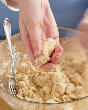 squeezing flaky pie crust dough to check moisture content