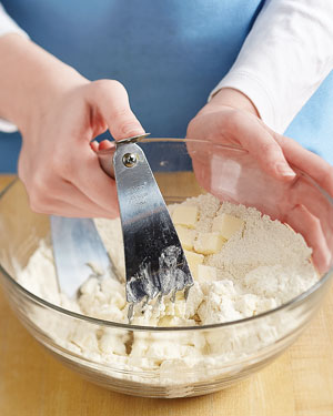 using a pastry blender to cut butter into flaky pie crust dough