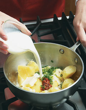 Add buttermilk to the cooked potatoes for a creamy texture.