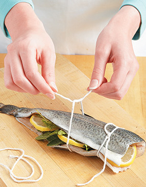Tie each trout closed for grilling with three pieces of kitchen string, then trim off the long ends.