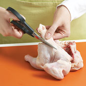 To split the hen, cut out the backbone with kitchen shears, then slice the bird down the center..