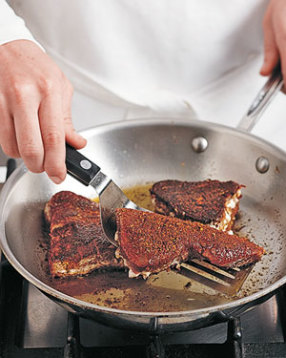 Blacken tuna steaks in a hot skillet. It's OK if they don't cook through, they'll finish cooking in the oven.