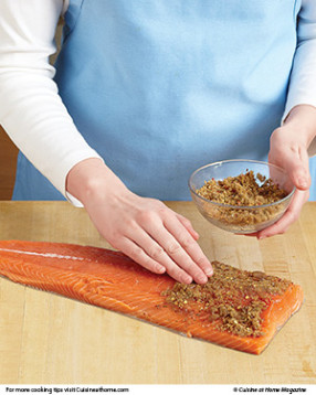 Press the rub mixture into the salmon, then place it on top of the plank on the grill.